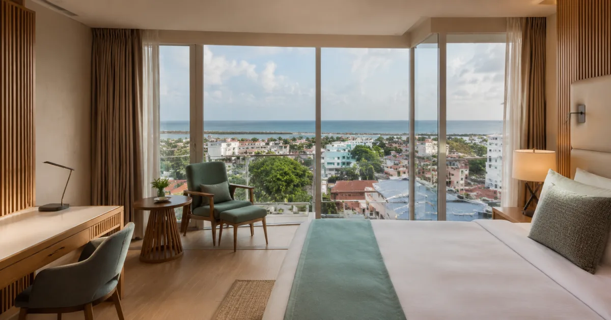 Suite de hotel contemporánea con área de trabajo y vista urbana hacia la costa atlántica de Georgetown.